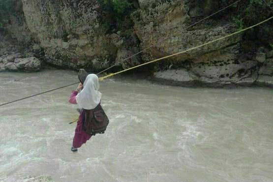 دانش آموزان این روستا با طناب به مدرسه می روند / آویزان شدن روی رودخانه خروشان برای درس خواندن ! +عکس