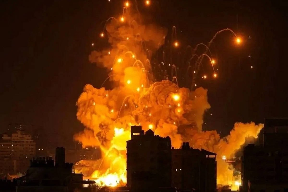 با وجود بمباران نوار غزه، یک جوان فلسطینی همچنان به آماده کردن غذای خود بر روی آتش، بر بام خانه‌اش ادامه می‌دهد.
