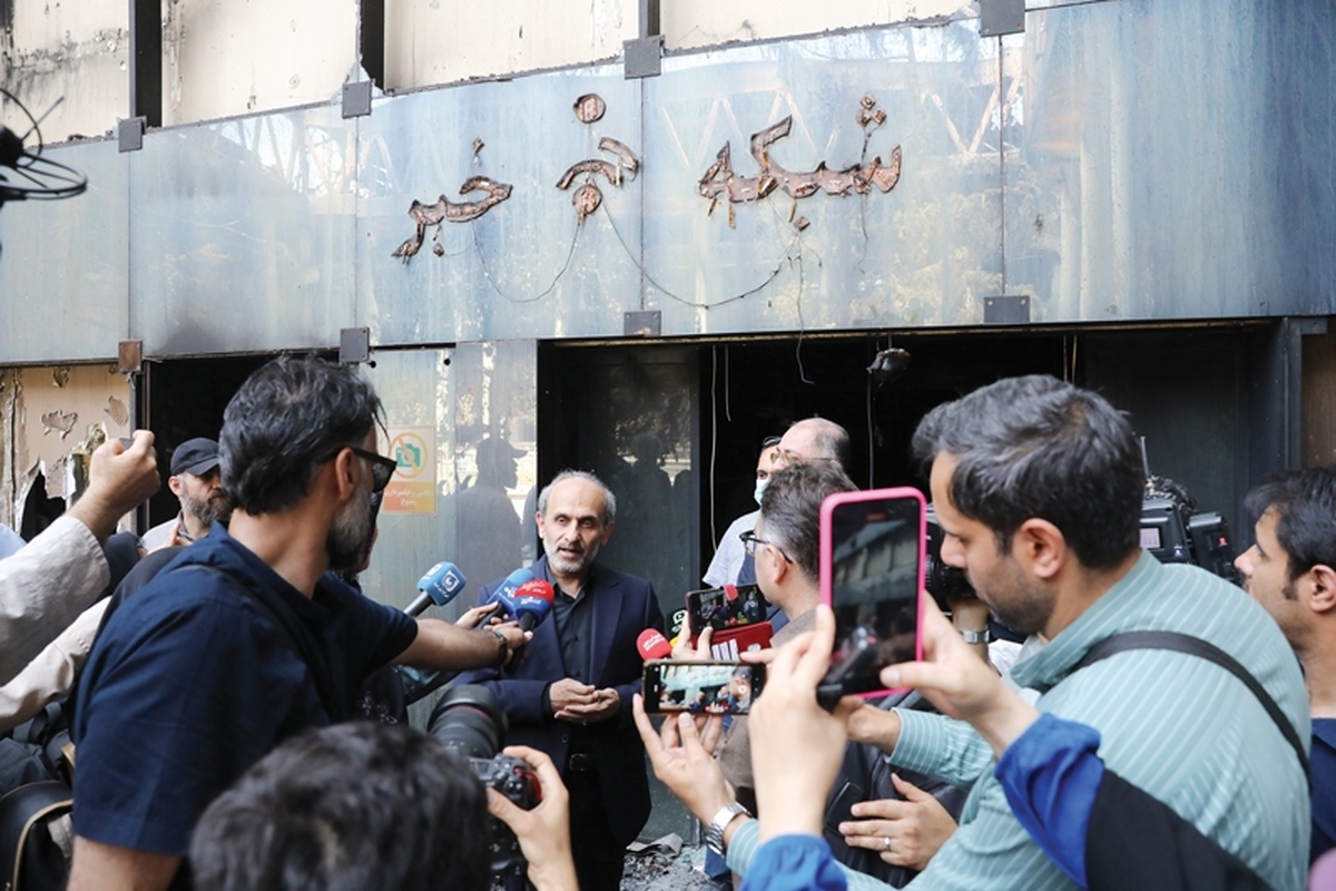 از میان آن ساختمانی که حالا رنگ دود گرفته و بوی تند آتش خاموش‌شده را می‌شود از نزدیک استشمام کرد، پرچم بزرگ ایران در اهتزاز است. این، اولین چیزی است که می‌توان از ساختمان شیشه‌ای سازمان صداوسیما مشاهده کرد. کمی نزدیک‌تر، خرده‌های شیشه و کاغذ‌های سوخته، ساختمان قدیمی خبر را در آغوش گرفته.